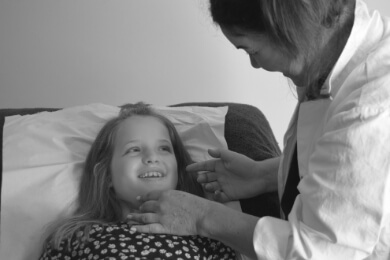 Young girl smiling receiving paediatric acupuncture