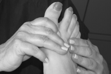 Reflexology being worked on a lady's foot